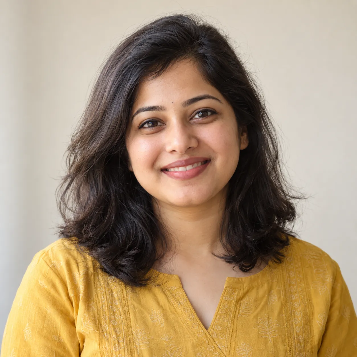 Young Indian woman on a balcony at golden hour, smiling at her phone